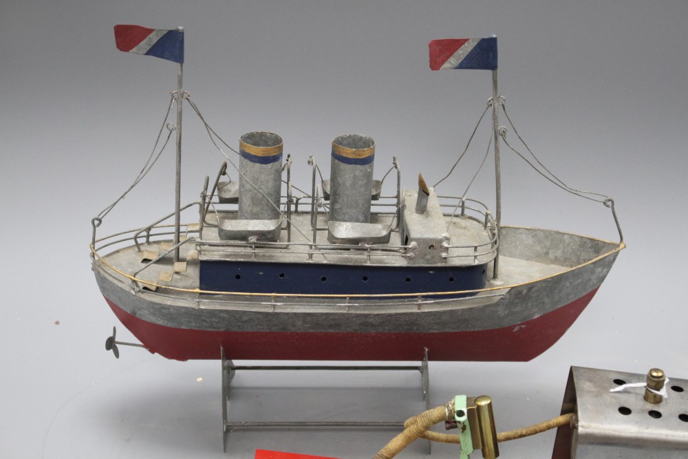 A 1950s Mamod ME1 clockwork steam engine, a Vane gear for a pond yacht and a modern painted metal model of a boat